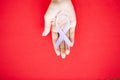 Womans hands holding purple domestic violence awareness ribbon Royalty Free Stock Photo