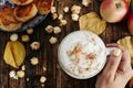 Womans hands with Hot cappuccino with popcorn, apple, cakes, le