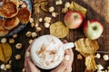 Womans hands with Hot cocoa with popcorn, apple, cakes, leaves