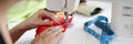 Woman sew on red fabric on a sewing machine