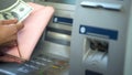Womans hands putting dollars in wallet, cash withdrawn from ATM, travelling