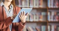 Womans hands on tablet in Library Royalty Free Stock Photo