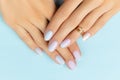 Womans hands with trendy manicure on blue background. Summer nail design