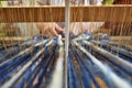 Womans hands weaving on a loom