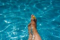 Womans legs with flower in blue pool Royalty Free Stock Photo