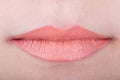 Womans lips with orange glossy lipstick