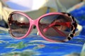 Womans sunglasses laying on the beach summertime