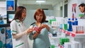 Women analyzing cardiology plls box in pharmacy shop Royalty Free Stock Photo