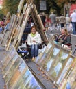 Women, artists, sitting on a pavement, their paintings placed on asphalt, blurred people on a background