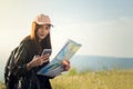 women asian with bright backpack looking at a map. View from back of the tourist traveler on background mountain, Female hands us