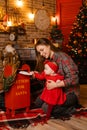 a woman is holding a baby and putting a letter in a mailbox for santa Royalty Free Stock Photo