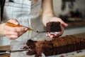 women baker cooking sweet chocolate brownies cake . Process of cooking, hands a piece of homemade chocolate cake on kitchen