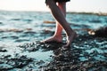 Women bare feet by the sea at sunset, selective focus