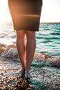 Women bare feet by the sea at sunset, selective focus