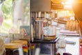 Women barista hand using coffee machine automatic preparing fresh coffee and pouring into glass cup Royalty Free Stock Photo