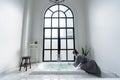 Women in bathrobe while carryin bathbomb in nice design jacuzzi bathtub with high transparant window in natural light setting