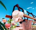 Women beach handbag and  sunglasses  straw hat  on bench at sea blue sky ,  tropical flowers white clouds  nature summer holiday b Royalty Free Stock Photo