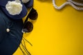 Women beach hat, sunglasses, flip flops and some white rope on a yellow background Royalty Free Stock Photo