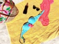 Women beachwear bikini  sunglasses dress and bag on yellow blanket at beach  sand Royalty Free Stock Photo