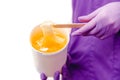 Women beautician holds jar of paste for sugar depilation shugaring, white background