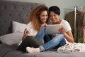 Women are beautiful, strong and compassionate.a couple using a tablet while sitting on the bed at home.