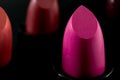 Women beauty products, luxury fashion and makeup concept with macro close up on a row of lipstick tubes in a line on dark Royalty Free Stock Photo