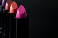 Women beauty products, luxury fashion and makeup concept with a row of lipstick tubes in a line on dark background with dramatic Royalty Free Stock Photo