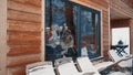 Women, best friends spending winter vacation in wooden mountain house. Drinking hot beverages and gossiping near the big