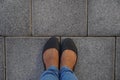 Women Black casual shoes standing and resting on asphalt concrete floor with square tiles. Top View. Concrete floor texture