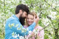 And woman in blooming garden. Young happy couple in love outdoors. Lovers on a walk in a spring blooming park. Royalty Free Stock Photo