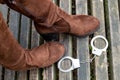 women boots and handcuffed on a wooden bench