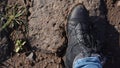 Women boots in the mud, detail of dirty boots and muddy, walk. Top down dirty black laced boots woman in blue jeans