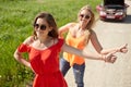 Women with broken car hitchhiking at countryside Royalty Free Stock Photo