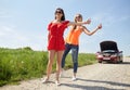 Women with broken car hitchhiking at countryside Royalty Free Stock Photo