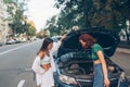 Two women with broken car on the road. Open hood Royalty Free Stock Photo
