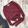 Women burgundy blouse on a wooden background