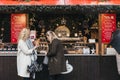 Women buy Bubble Waffles in Winter Wonderland Christmas Fair in London, UK.