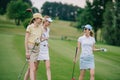 women in caps with golf equipment having conversation Royalty Free Stock Photo