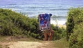 Women carrying beach chair wlking through dunes in Montalk