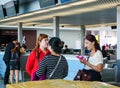 Women chatting at the check-in counters in TSN airport, Saigon, Vietnam