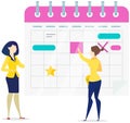 Women check calendar with planned activities. Colleagues planning work schedule, timetable