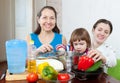 Women with child cook vegetables in the kitchen