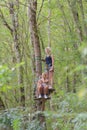 Women climbing in forest adventure rope park
