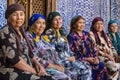 Women in colorful dresses sitting and resting in Khiva, Uzbekistan.