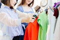 Women consider made a decision compare two shirt color and size for good value to buying a new cloth in fashion shop Royalty Free Stock Photo