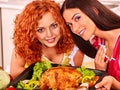 Women cooking chicken at kitchen