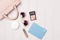 Women cosmetics and fashion items on table with camera and passport. Top view