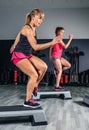 Women couple training over steppers in aerobic