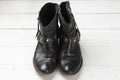 Women cowboy boot. Black leather shoes on a white wooden table. Composition of clothes. Flatlay