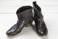 Women cowboy boot. Black leather shoes on a white wooden table. Composition of clothes. Flatlay